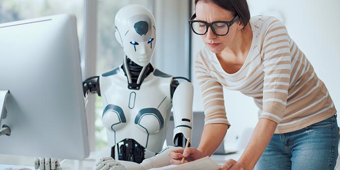 Was ist Künstliche Intelligenz - Frau mit Roboter am PC